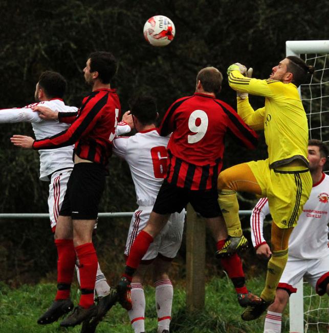 Dragons goalkeeper Peter Blain deals with a corner in the box